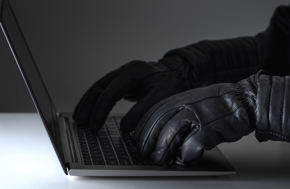 Schwarze Handschuhe tippen auf Tastatur